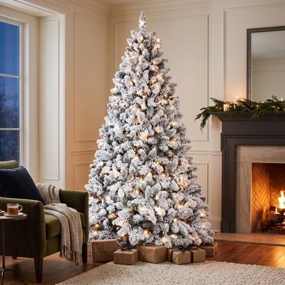 Flocked Pre-Lit Christmas Tree lit beside a fireplace