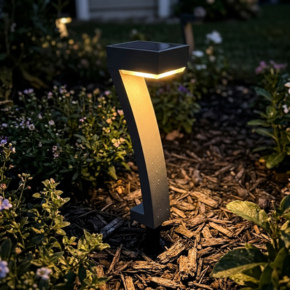 Solar path light glowing in a garden bed at night